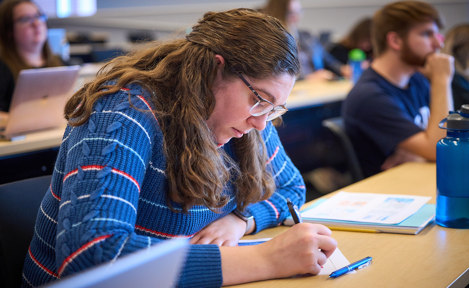 girl taking notes in class