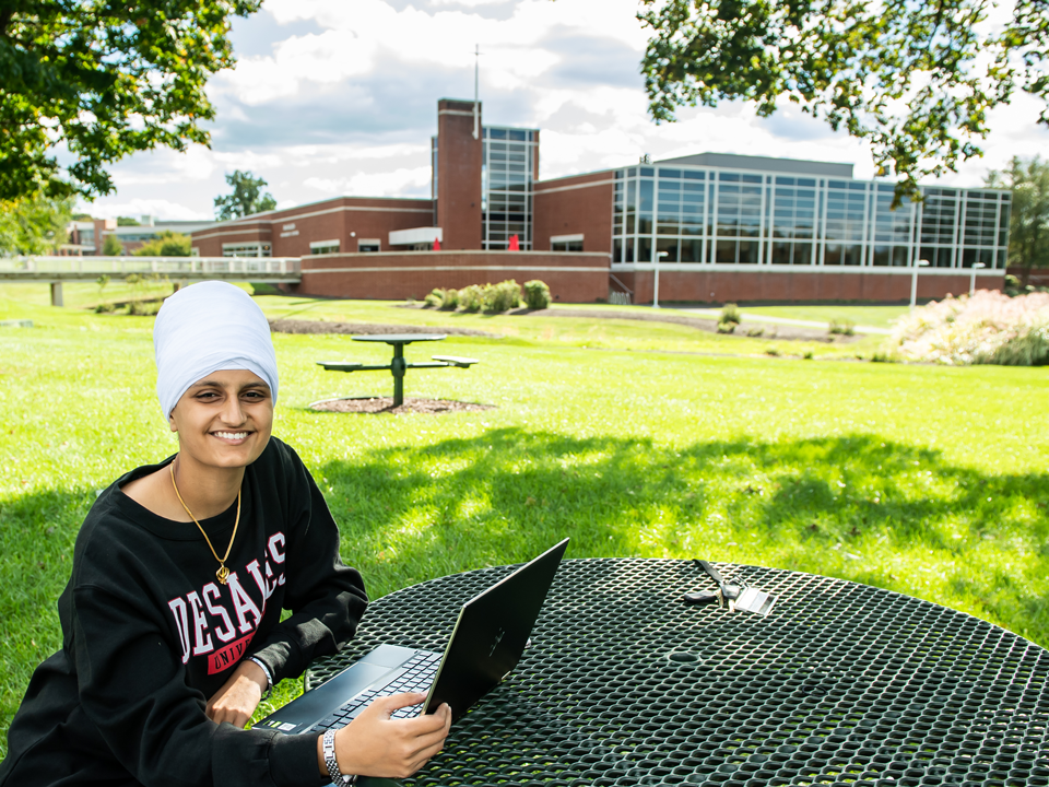 student at picnic table on campus