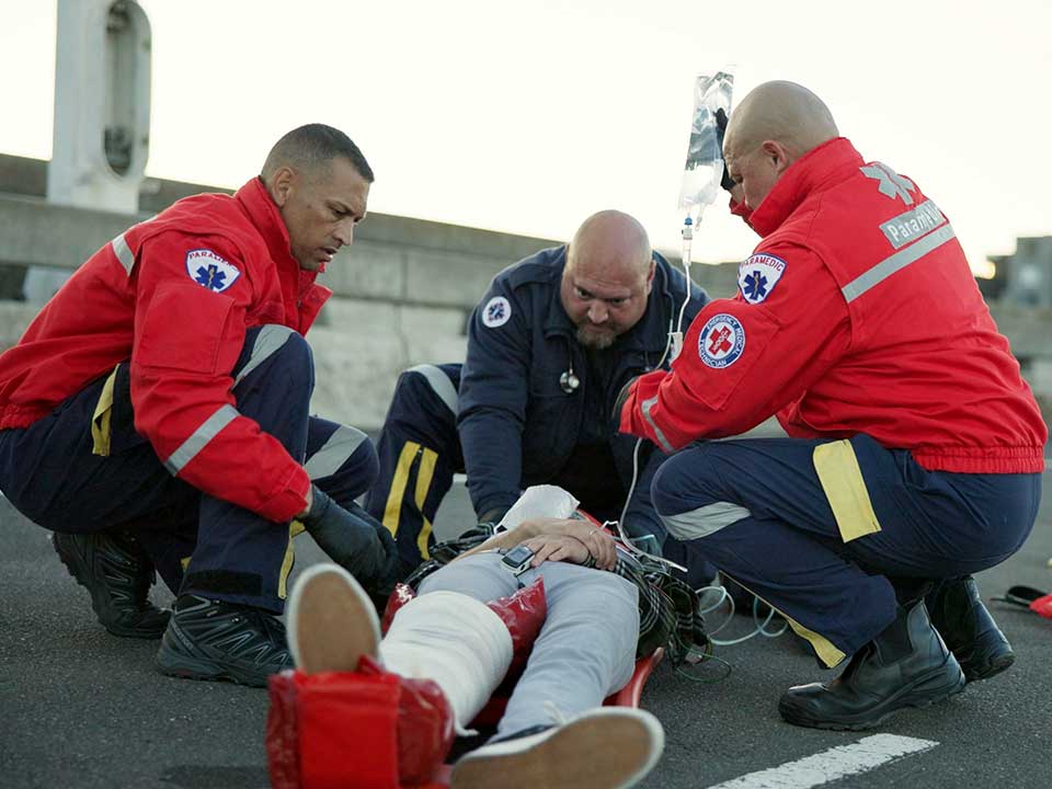 group of paramedics helping a patient