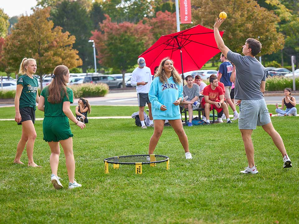 students playing spikeball on campus