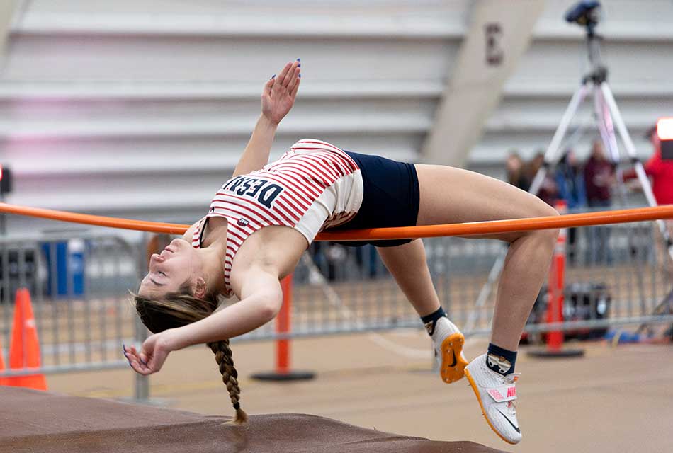 female athlete jumping over high jump bar