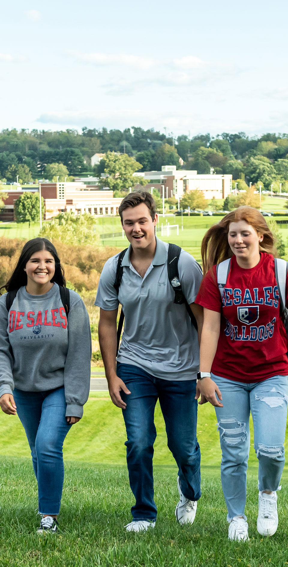 students walking with campus behind them