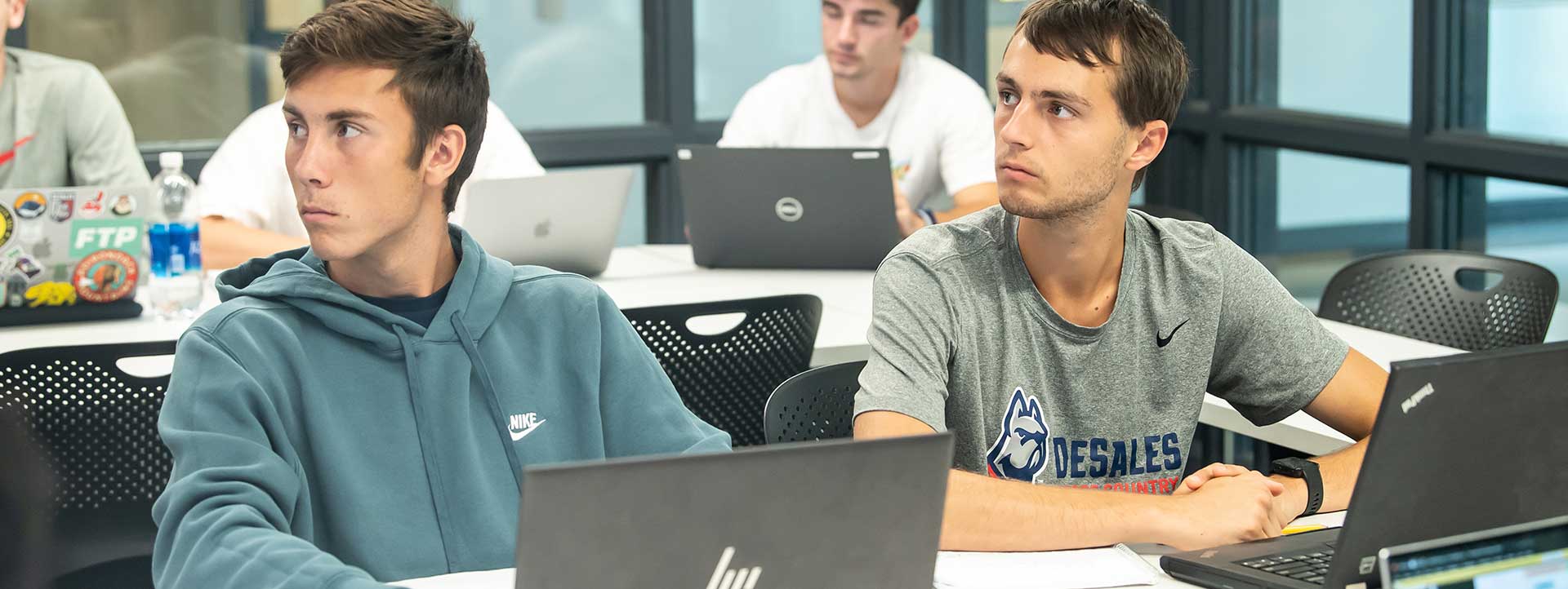 student in a classroom with their laptop