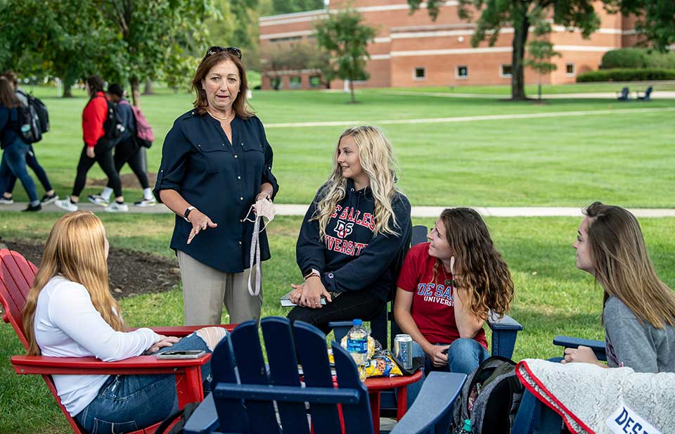 students sitting in chairs on campus