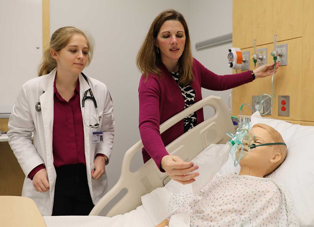 student and professor in simulation center