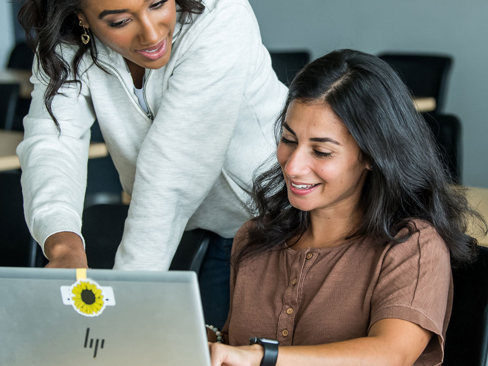 two students looking at a laptop