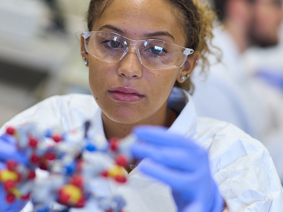 girl looking at a molecule model