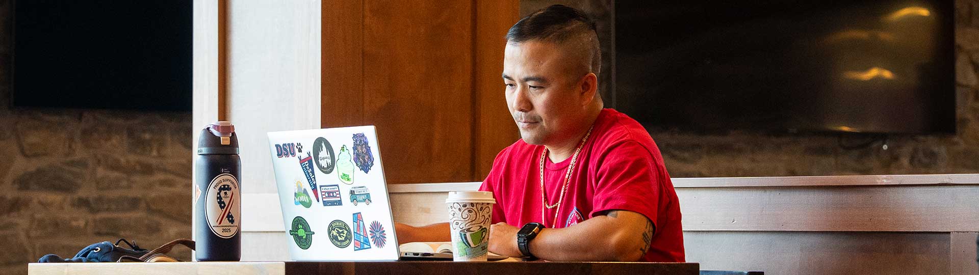 student using laptop at cafe