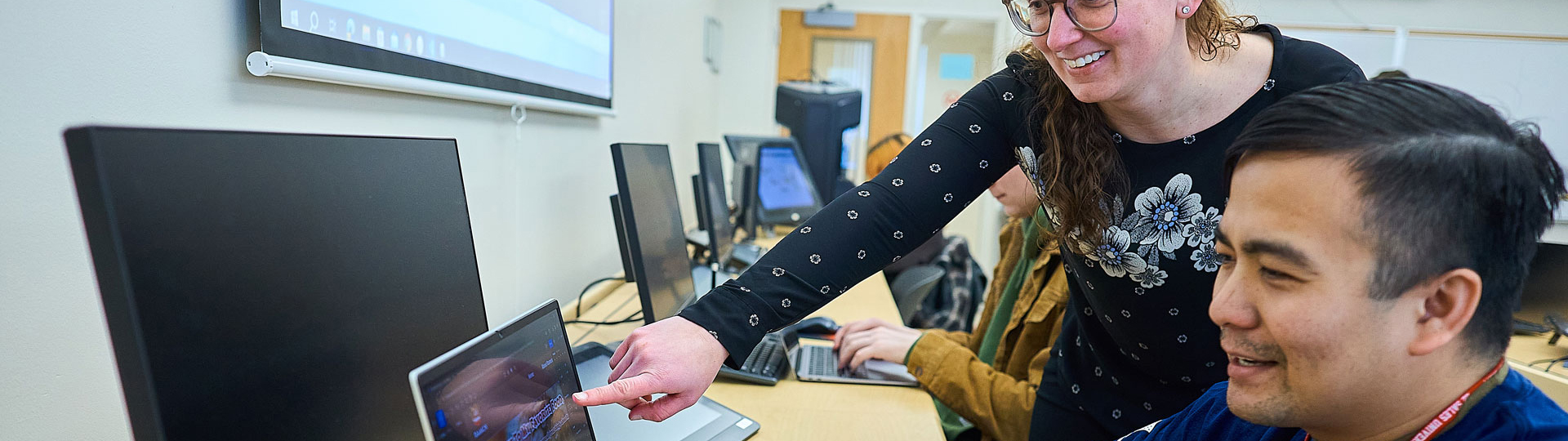 teacher helping a student on the computer