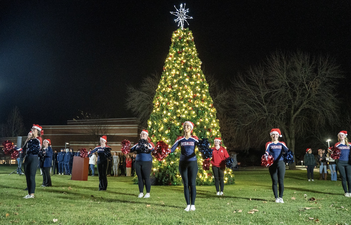 Students gathered around a Christmas tree