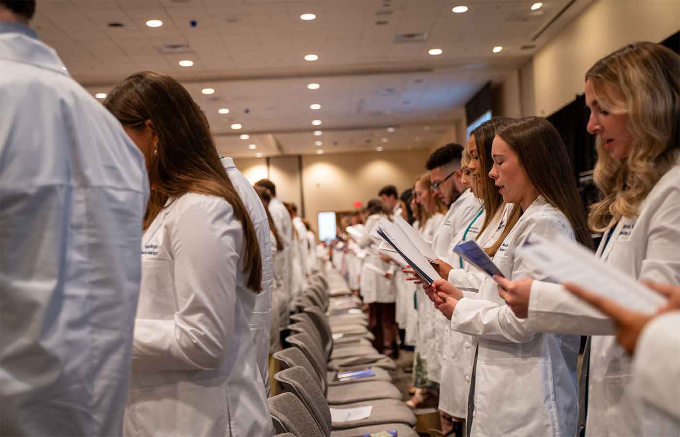 Physician assistant students receive their white coats at completion ceremony