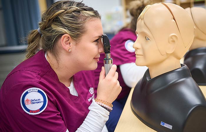 student nurse examining a manakin