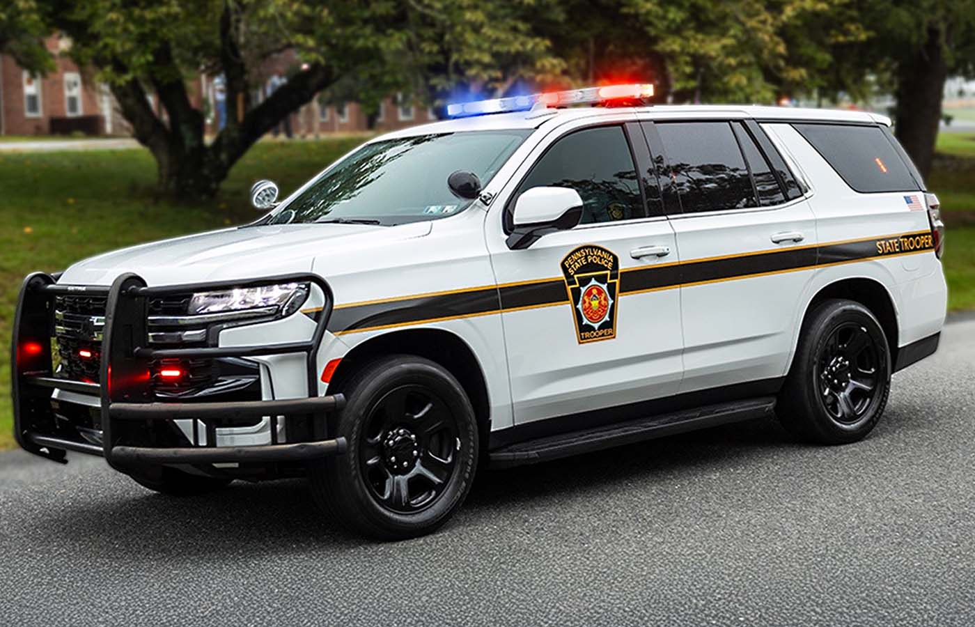 Pennsylvania State Police patrol SUV with emergency lights activated, parked on a roadway.