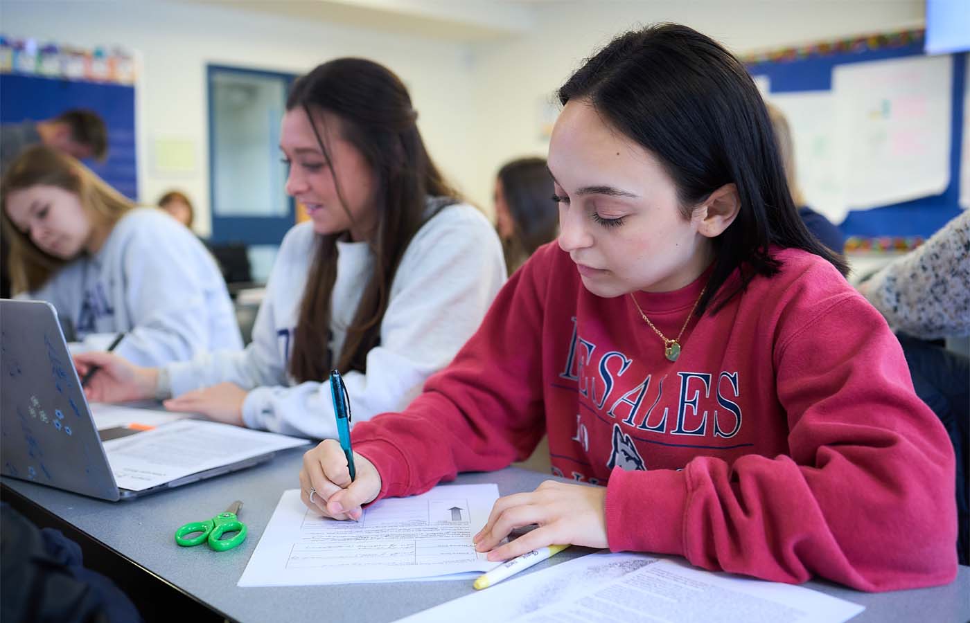 DeSales University students seated at desks in a classroom while studying.